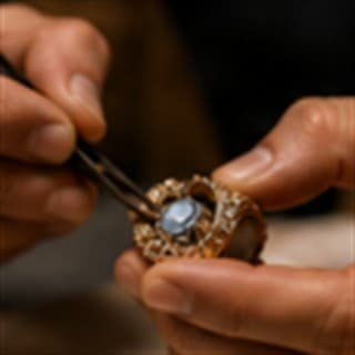 Master jewellery craftsman delicately setting gemstone into ring